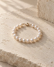 Pearl bracelet displayed on a softly lit neutral surface.