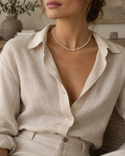 Pearl necklace styled with soft neutral clothing in natural light.